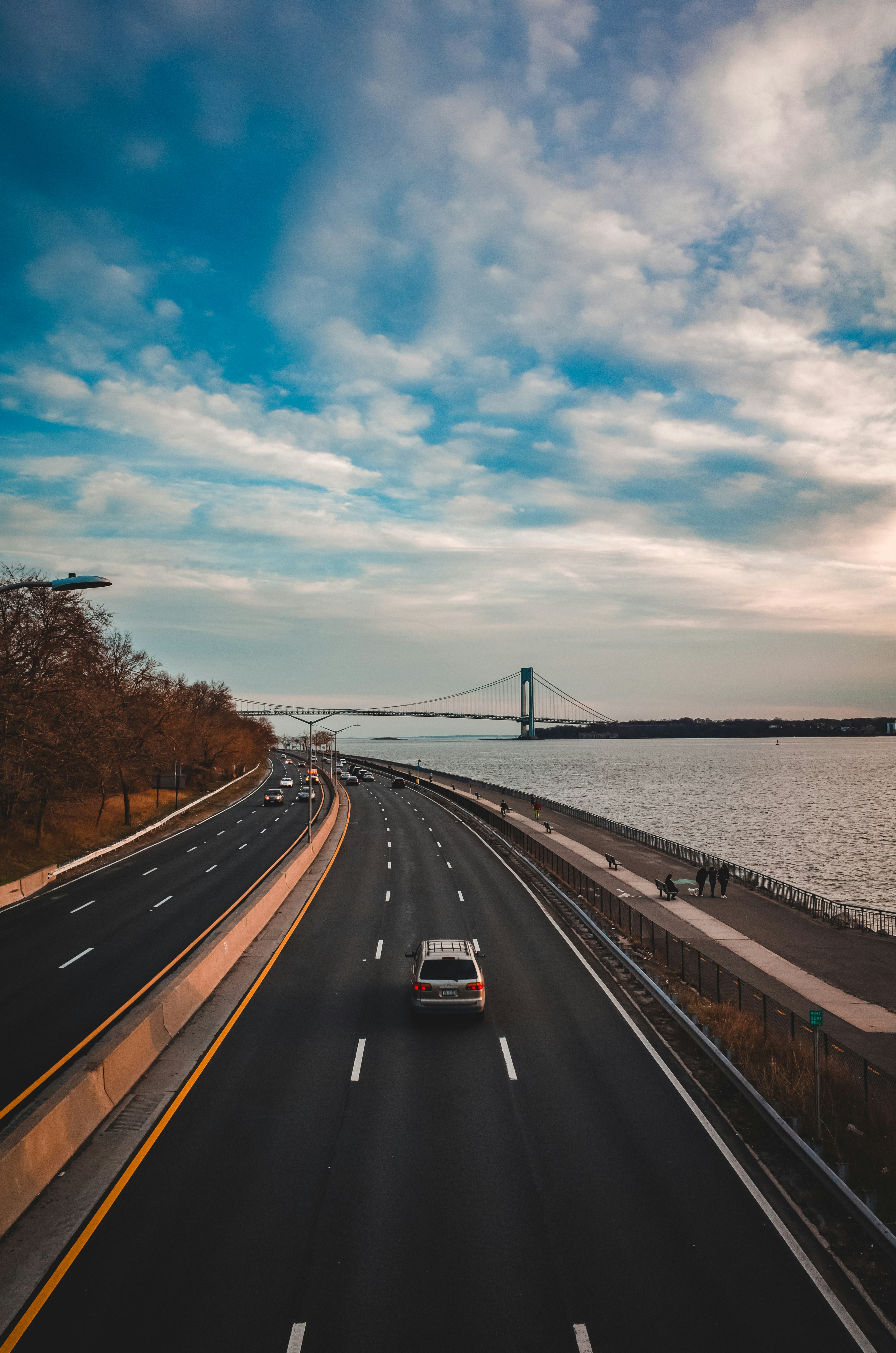 Highway scene with car driving on multi-lane road with bridge in background